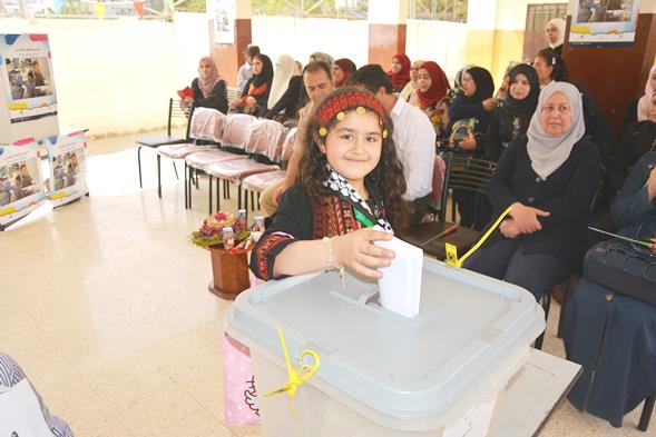 صورة اثناء قيام طالبة من الصف الثاتي بالإدلاء بصوتها